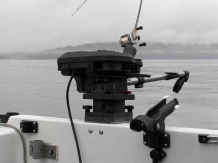 An electric downrigger mounted on the side of a boat.