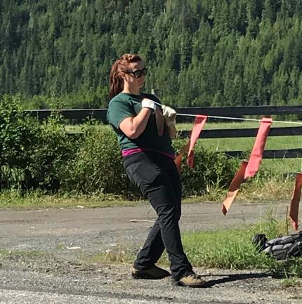 A conflict specialist hangs fladry around a livestock pasture.