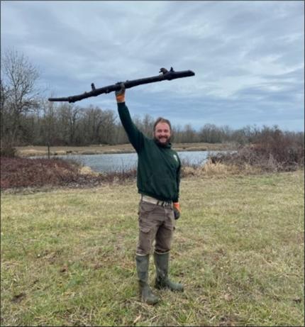 Assistant Manager Breitenstein triumphantly holds up a stick that was successfully dislodged from deep inside a drainpipe.