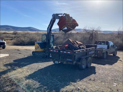 Abandoned couches being loaded into a dump trailer