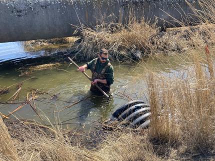 Assistant Manager Furguseon unclogging a culvert