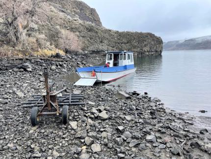 A boat on a rocky shore with an ATV