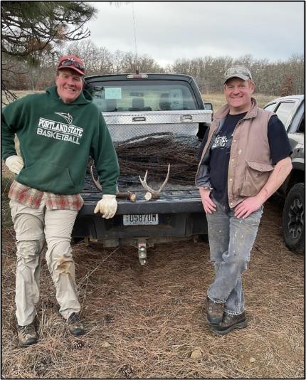 Master Hunter Volunteers Haskell and Rudberg standing behind a pick up.