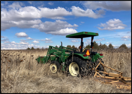 A green tractor ready to start mowing.