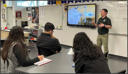 Biologist Cook teaching a classroom of high school students.