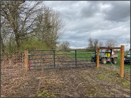 Assistant Manager Breitenstein and Manager Hauswald secure cattle panels down an embankment.