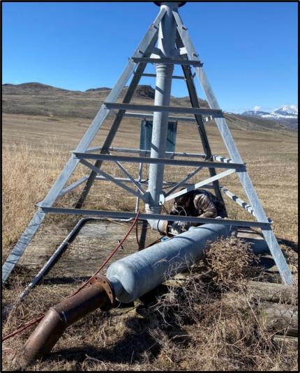 Staff member Rise unbolting the filter and valve from the center pivot.