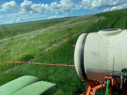 A tractor tank spraying fields