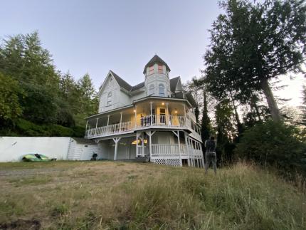 A large house with a person counting bats