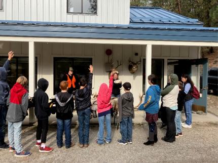 Several kids around a WDFW Technician