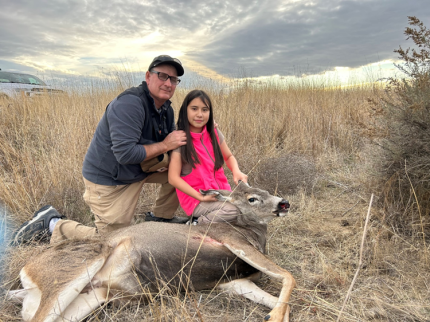 A young hunter with a recently harvested deer.  