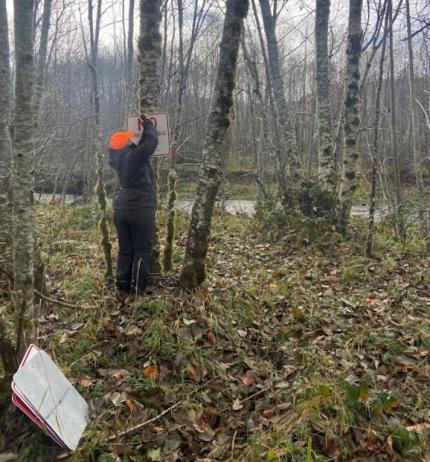 Technician Crane hangs the first of many ‘No Trespassing’ signs to mark the boundary of the Mudflow Unit. 