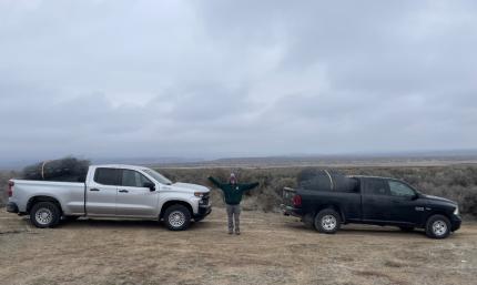 Nason standing between two trucks with pen material in the back