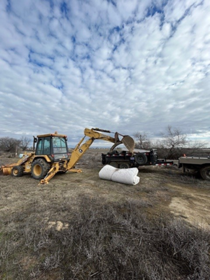 A tractor picking up a mattress