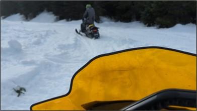 Two wildlife conflict specialists on snowmobiles