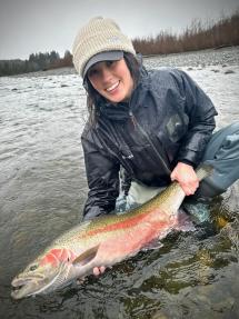 Woman holds wild steelhead in water